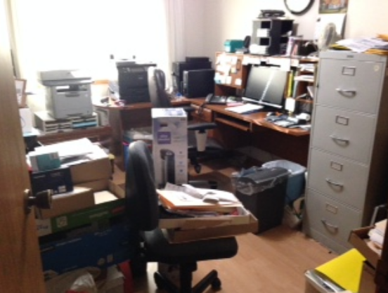 Cluttered office workspace before