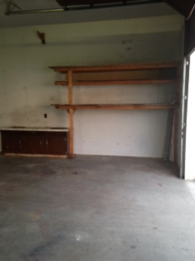 Empty garage with wooden shelving after