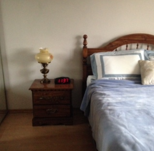 Tidy bedroom with wooden bed and nightstand after